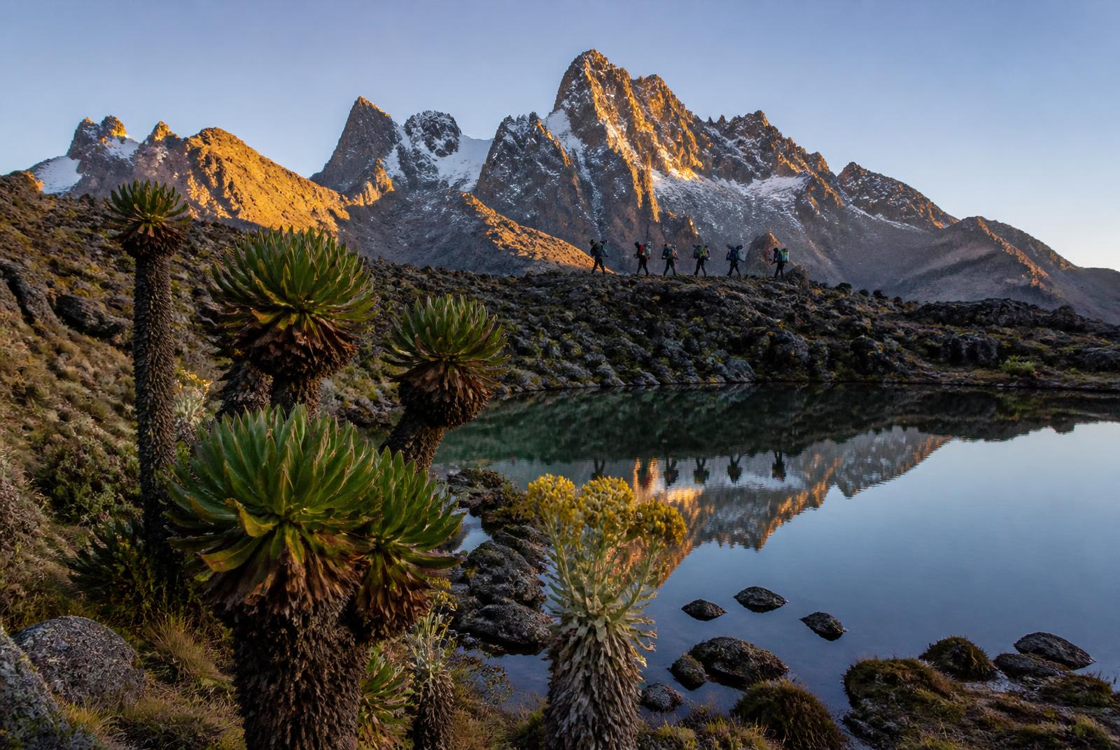 Snow-dusted peaks of Mount Kenya at sunrise above an alpine tarn